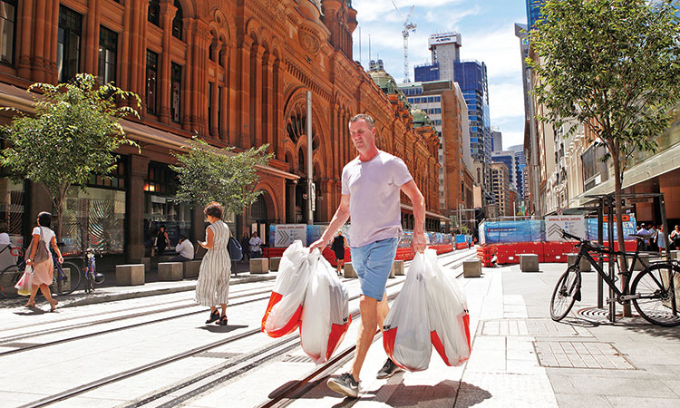 A man carries several shopping bags as he walks along George Street in Sydney’s central business district, Australia. Reuters