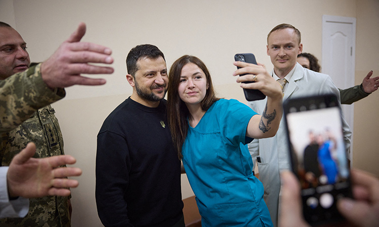 Ukraine's President Volodymyr Zelenskiy poses for a picture with staff of a military hospital in Mykolaiv, Ukraine. Reuters