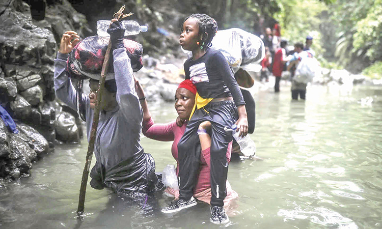 Haiti migrants wade through water as they cross Darien Gap from Colombia to Panama in hope of reaching the US.   File/Associated Press