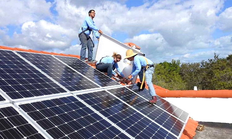 Workers install solar panels on a rooftop at a home in Jefferson, North Coast, California. AFP