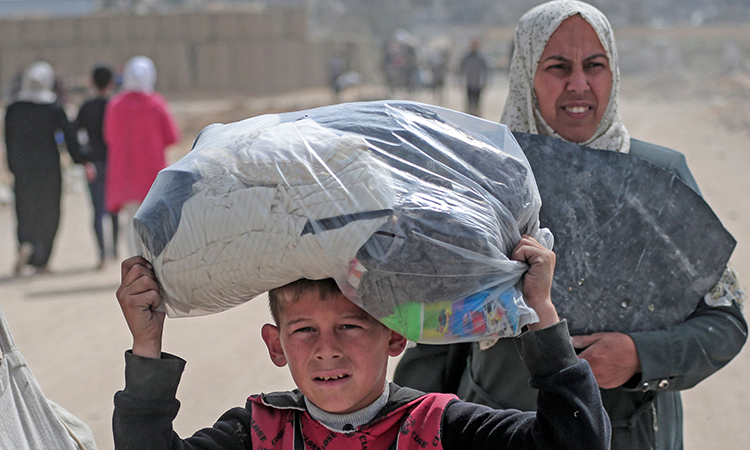 Palestinians walk past the rubble of houses destroyed by Israeli bombardment in Khan Yunis in the southern Gaza Strip on March 6, 2024, amid the ongoing conflict between Israel and the Hamas movement. AFP