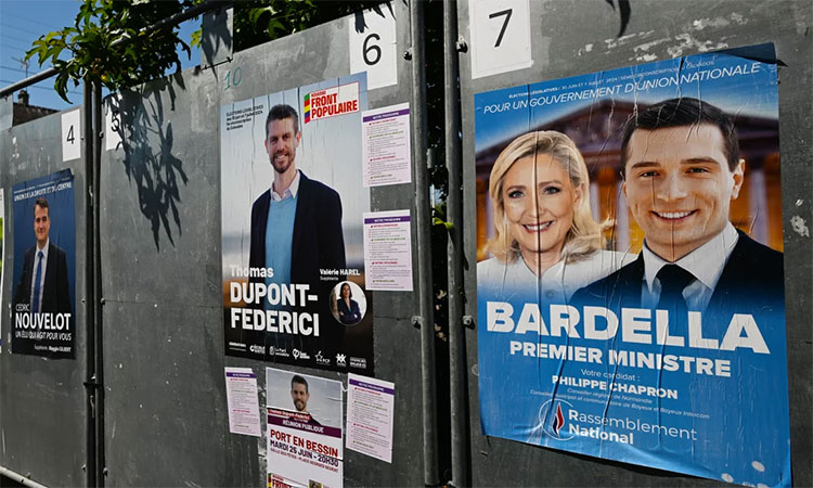 Posters with images or names of local candidates for the first round of the 2024 French legislative elections displayed in front of the local town hall in Port-en-Bessin-Huppain, Normandy, France. Reuters