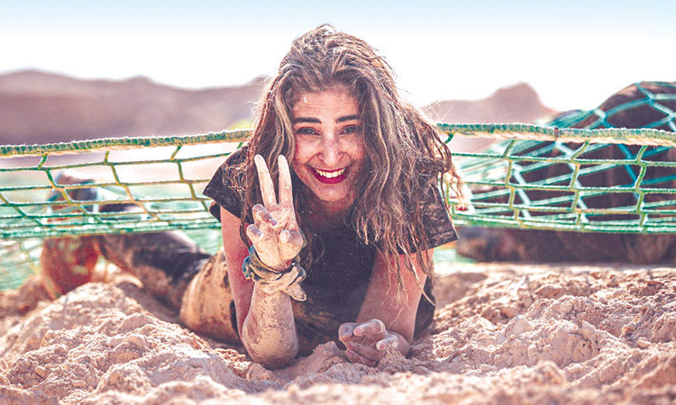A participant  gestures while taking on Tough Mudder’s Kiss the Mud Obstacle. File
