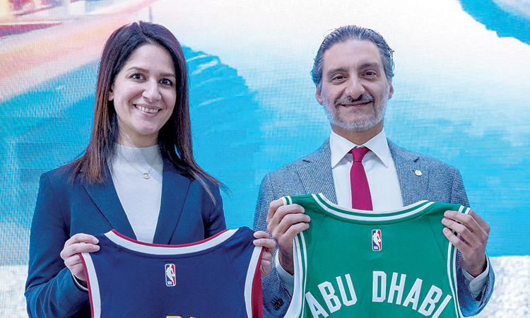  Saleh Al Geziry, and Dina Ahmad, NBA Europe and Middle East Vice President, pose with jerseys.