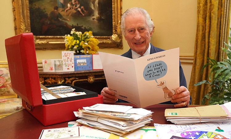 King Charles pictured laughing as he reads card from well-wisher among 7,000 sent since cancer diagnosis