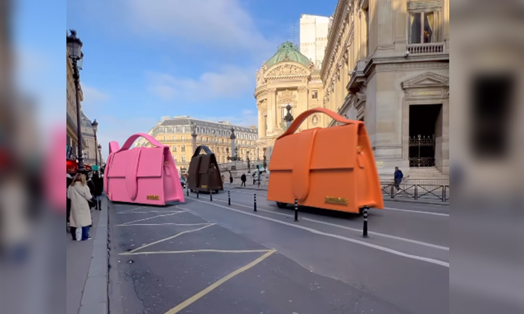 French fashion brand showcases giant forms of its attractive bags zooming through Paris on wheels