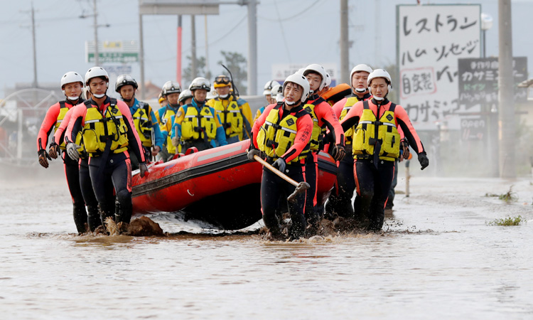 Japan rescuers wade in muddy waters to find typhoon survivors