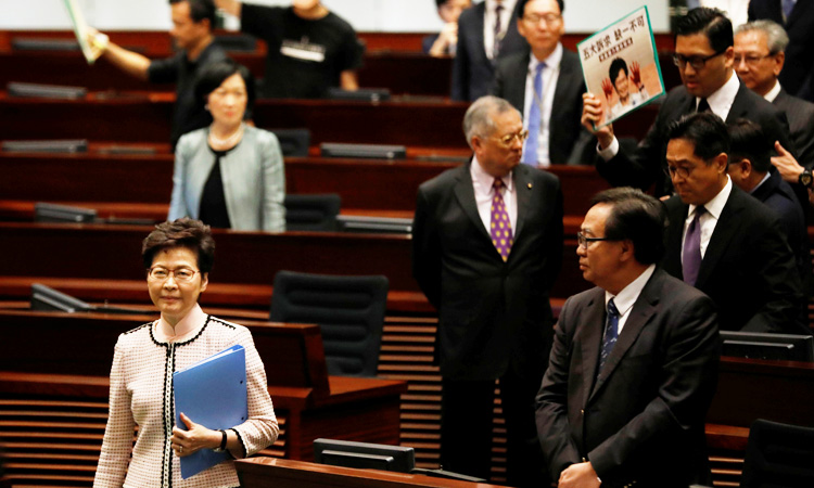 Hong Kong leader halts policy speech as lawmakers disrupt session