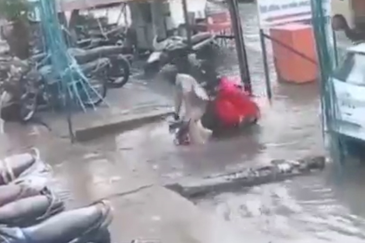 VIDEO: Couple riding scooter falls into a waterlogged ditch, video goes viral