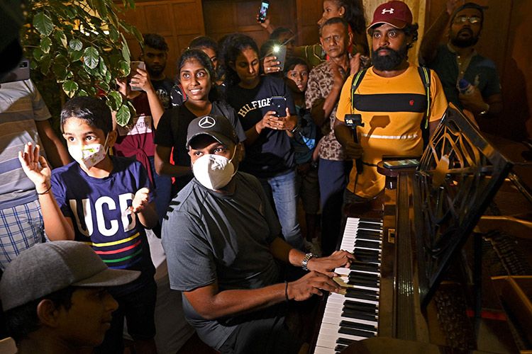 VIDEO: Relaxed Lankan protesters sing, play piano in vacant Presidential Palace