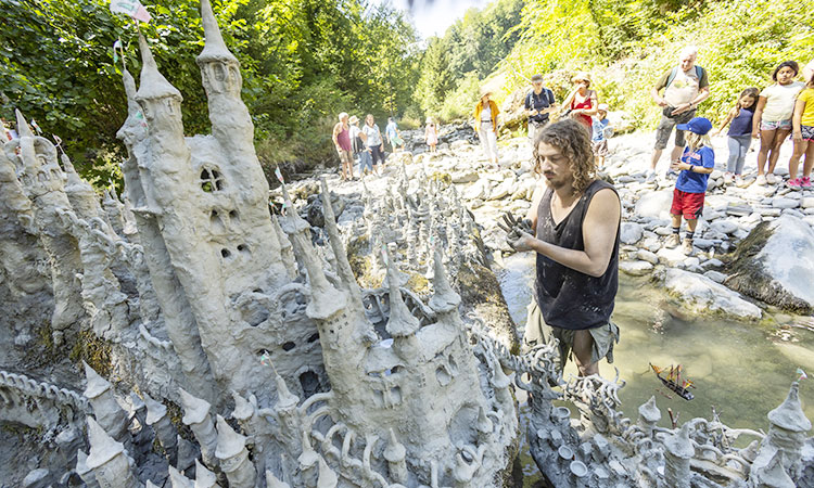 Swiss artist sculpts sprawling model castle on dried river bank