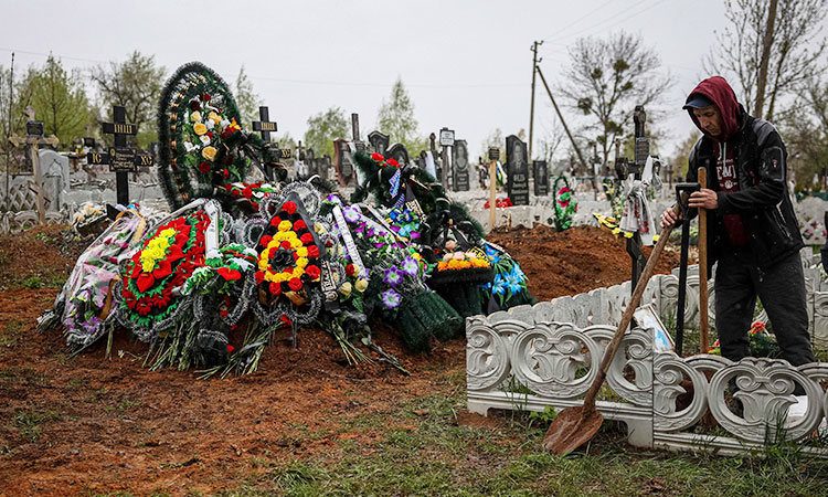 'Unbridled grief:' Ukrainian woman buries toddler son, husband after strike