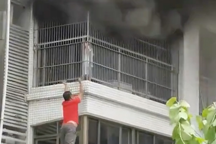 VIDEO: Brave men cut through metal grille bars to rescue child trapped in apartment fire in China 