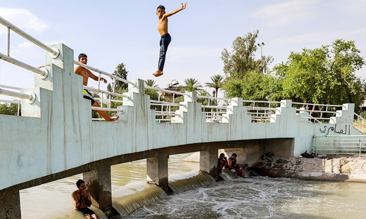 Iraqis flock to river or ice rink to escape searing heat