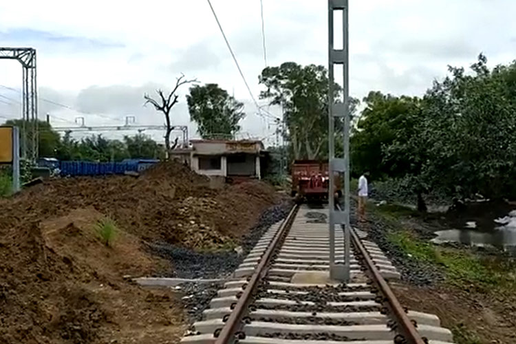 Contractor erects electric pole right in the middle of train tracks in India